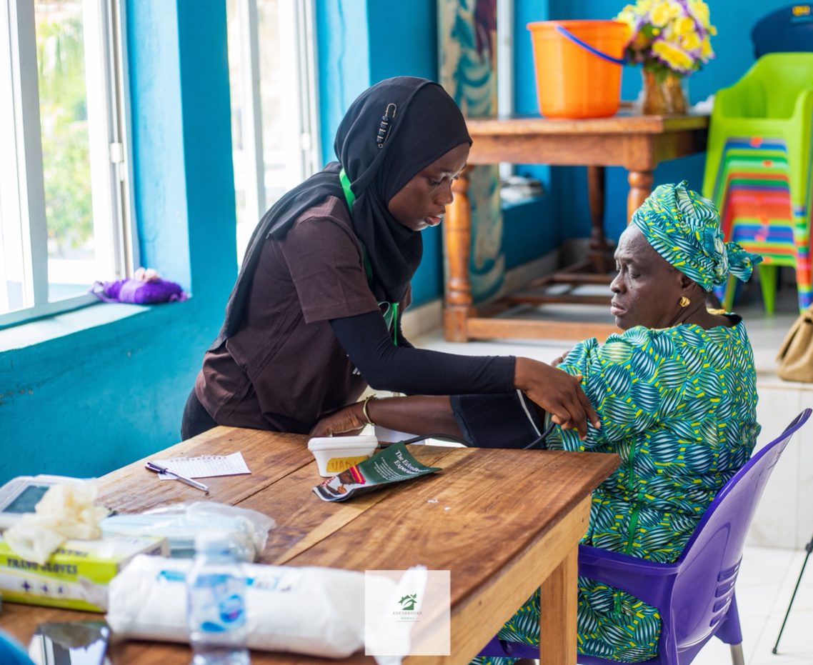 A volunteer taking a guest's blood pressure at the Mokola outreach